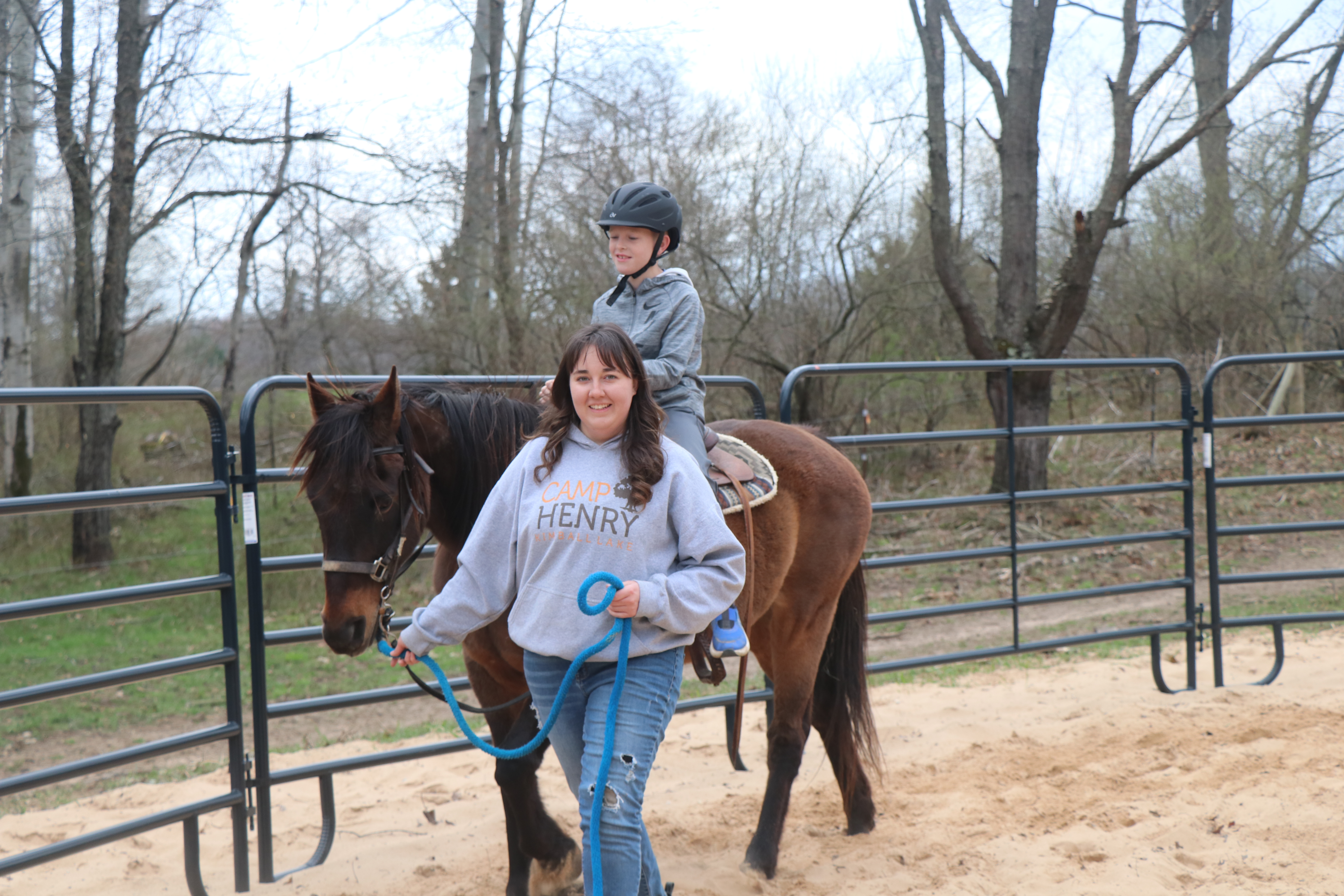 Child on a camp horse with a Camp Henry staff member