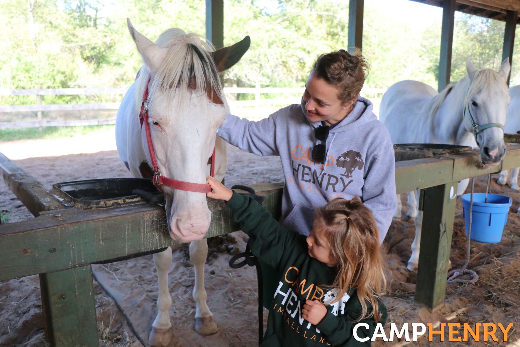Mom and daughter petting a camp horse at Camp Henry